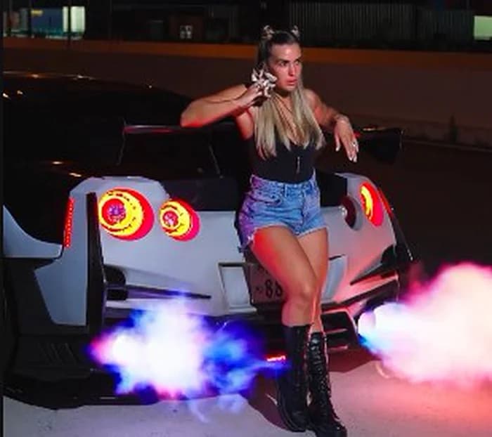 Nissan GT-R R35 with twin colored smoke at night in Tokyo