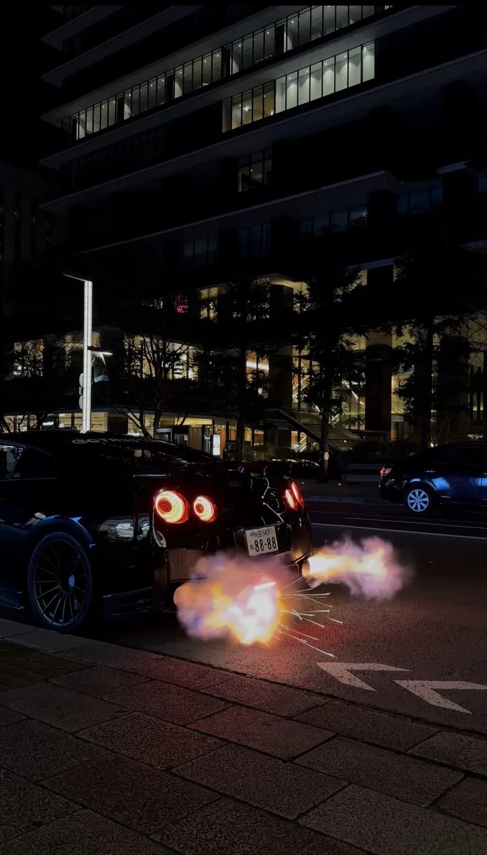Nissan GT-R R35 with backfire flames at night in Tokyo